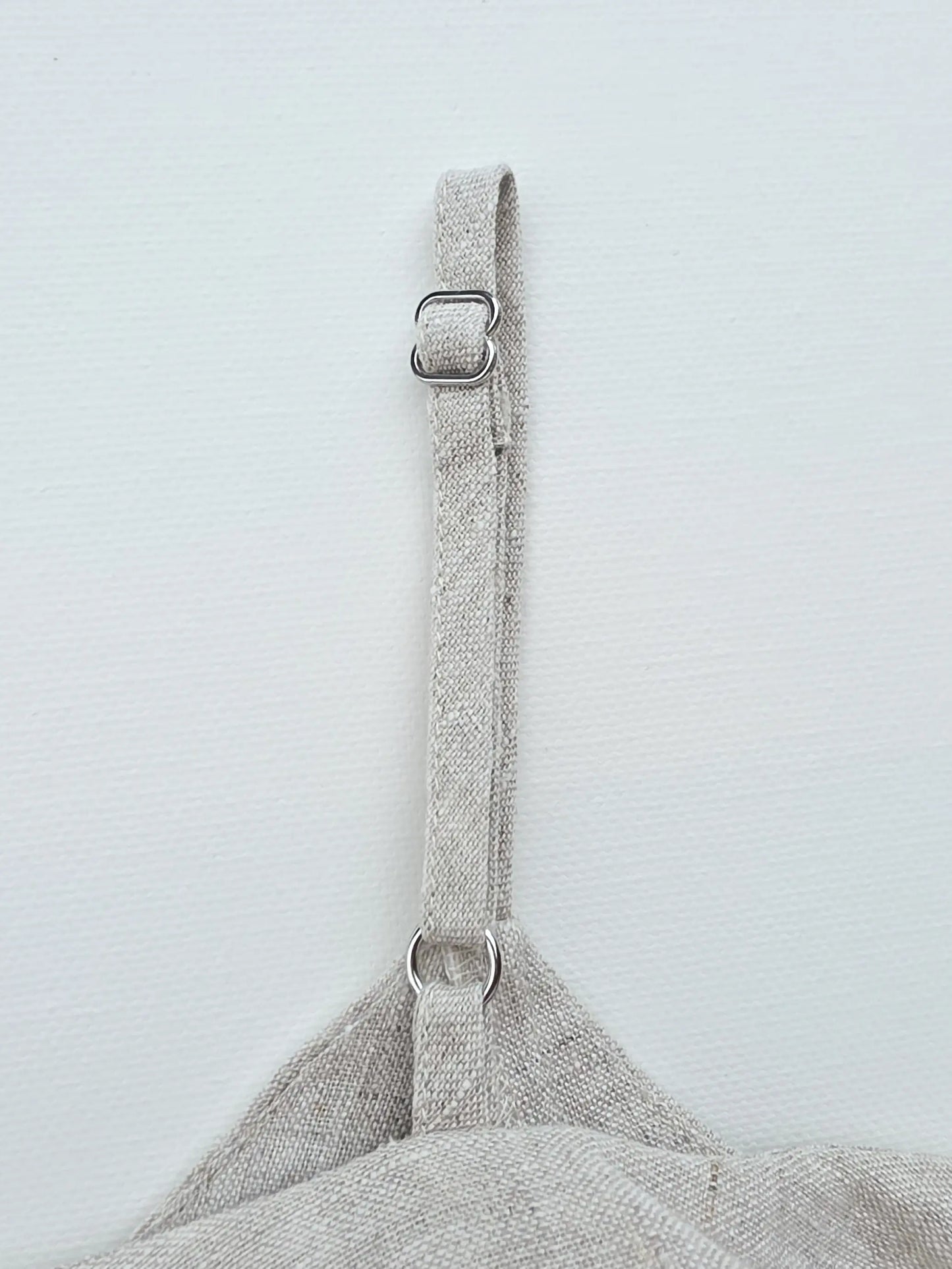 Close-up detail of adjustable shoulder straps on a handmade natural flax linen top.